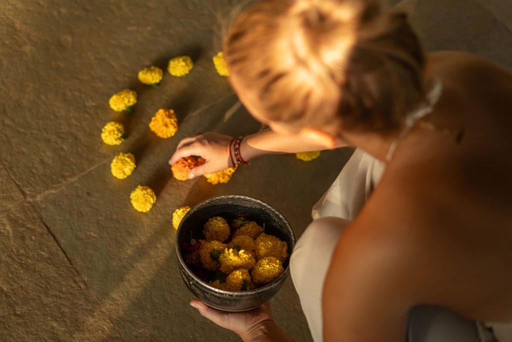 Christina Berhane bei einem Sound-Healing-Ritual mit gelben Blüten